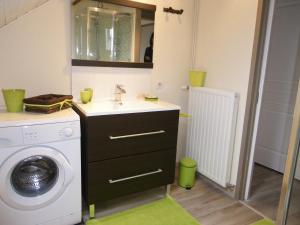 een badkamer met een wasmachine en een wastafel bij Gîte de campagne Dromard in Sancey-le-Long