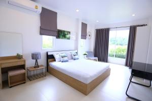 una camera con un grande letto e una grande finestra di Thacha Pool Villa B a Hua Hin