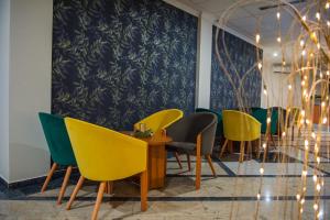 a dining room with yellow and green chairs at Hotel CITY in Prnjavor
