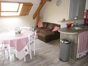 a kitchen and living room with a table and a couch at Gîte de campagne Dromard in Sancey-le-Grand