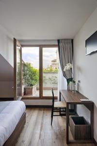 1 dormitorio con cama, escritorio y ventana en My Bed, en Milán