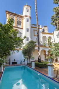 塞維利亞的住宿－Villa Elvira, exclusive Pool and Gardens in the heart of Sevilla，大楼前的游泳池