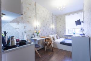 a small room with a kitchen and a bed in it at Guests Love on Kazanskaya in Saint Petersburg
