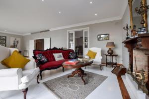 a living room with a red couch and a table at Villa Antumalal B&B in Málaga