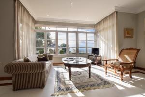 ein Wohnzimmer mit einer Couch und einem Tisch in der Unterkunft Villa Antumalal B&B in Málaga