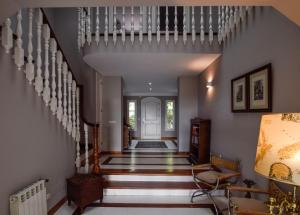 a hallway of a home with a staircase with white walls at Villa Antumalal B&B in Málaga