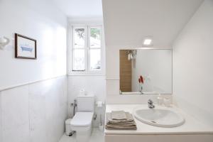 a white bathroom with a sink and a toilet at Villa Antumalal B&B in Málaga