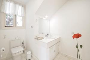 a white bathroom with a sink and a toilet at Villa Antumalal B&B in Málaga