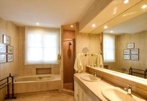 a bathroom with two sinks and a bath tub and a tubermott at Villa Antumalal B&B in Málaga