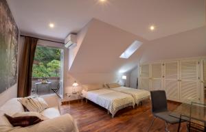 ein Schlafzimmer mit einem Bett, einem Sofa und einem Fenster in der Unterkunft Villa Antumalal B&B in Málaga + 35 Fotos