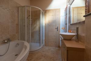 een badkamer met een bad, een wastafel en een douche bij Toilain in Livigno