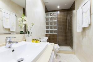 a white bathroom with a sink and a toilet at Apartamentos El Tajo & SPA in Ronda +20 photos