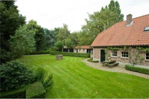 a large yard with a house and a garden with a bench at de Zeilende kraay in Katwijk