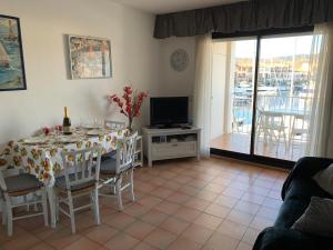 een woonkamer met een tafel met stoelen en een televisie bij Port Grimaud Les Voiles in Grimaud