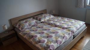 ein Schlafzimmer mit einem Bett mit einer Decke darauf in der Unterkunft Ferienwohnung auf einem richtigen Bauernhof in Finkenstein