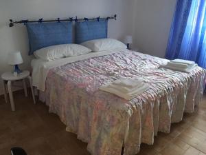 um quarto com uma cama com um cobertor e almofadas em Mancini Michela Alloggio uso turistico em Acilia
