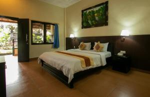 a bedroom with a bed and a painting on the wall at Bali Sandy Resort in Kuta