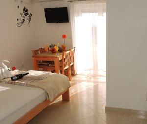 ein Schlafzimmer mit einem Tisch und einem Bett sowie ein Esszimmer in der Unterkunft Iva Apartmani in Tribunj