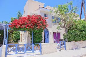een huis met rode bloemen in een blauw hek bij Villa Irina Polis in Polis Chrysochous