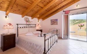um quarto com uma cama e uma grande janela em Villa Bella Sole em Kalipádhon