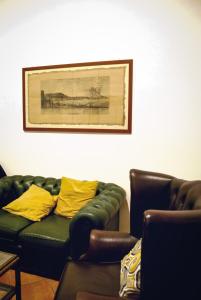 a living room with a green couch and yellow pillows at Locanda Dell'Arte in Naples