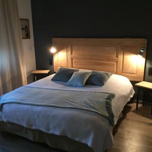a bedroom with a large bed with blue pillows at Chambres d'hôtes L'Ecrin des Saveurs in Schwenheim