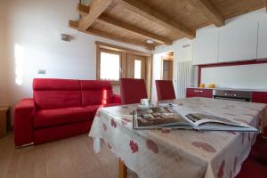 een woonkamer met een tafel en een rode bank bij Toilain in Livigno +25 foto's