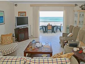 a living room with a couch and a television and a table at Elaia Sitia Center Sea View Apartment in Sitia