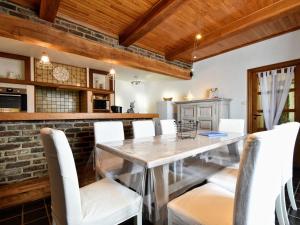 comedor con mesa de cristal y sillas blancas en Detached holiday home in Goesnes with private pool en Goesnes