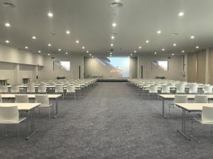 a large room with rows of tables and white chairs at MH Atlantico in Peniche +42 photos