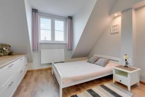 - une chambre blanche avec un lit et une fenêtre dans l'établissement Apartament Sopocki Kasztanowy, à Sopot