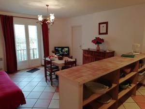 a kitchen with a counter and a dining room with a table at Comfortable flat with pool in Quend
