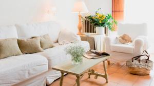 a living room with a white couch and a table at Mas del Mar in Sant Pere Pescador