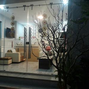 una sala de estar con un árbol en una habitación en Dang Nguyen Guesthouse, en Da Lat