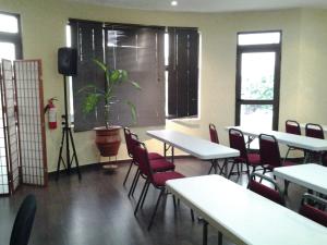 een kamer met tafels en stoelen en een potplant bij Access Inn in Accra