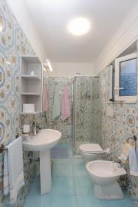 łazienka z 2 umywalkami, toaletą i oknem w obiekcie La dea bendata w mieście Minori
