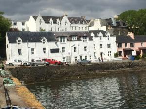 a large white building next to a body of water at The Rosedale Hotel in Portree