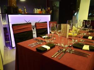 uma mesa com copos de vinho e guardanapos em Net Hotel Pitesti em Piteşti