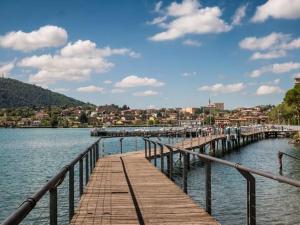 a wooden pier in the middle of a body of water at Casa Artisti del Sole in Paratico