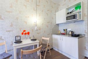 una piccola cucina con tavolo e forno a microonde di Guests Love on Kazanskaya a San Pietroburgo