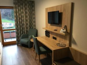 Biberach bei OffenburgにあるLandgasthof Kinzigstrandのテーブル、テレビ、椅子が備わる客室です。