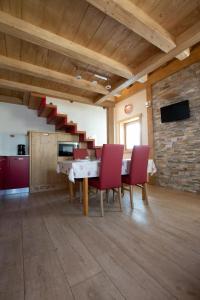 ein Esszimmer mit einem Tisch und roten Stühlen in der Unterkunft Toilain in Livigno