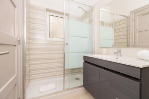 een badkamer met een glazen douche en een wastafel bij Lisbon Times Apartments in Lissabon +60 foto's