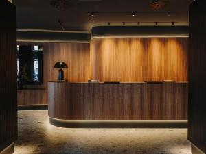 an office lobby with a wooden reception desk at El Môderne Hotel in Gijón