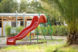 een speeltuin met een rode glijbaan in een park bij Boutique Camping Materada Beach in Poreč
