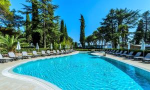 a swimming pool with lounge chairs and trees at Boutique Camping Materada Beach in Poreč