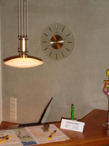 un orologio su una parete sopra una scrivania di legno di Hotel Kurallee a Meersburg