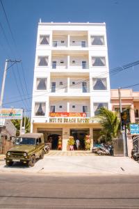 einem grünen LKW, der vor einem weißen Gebäude parkt in der Unterkunft Mui Ne Beach Hotel in Mui Ne