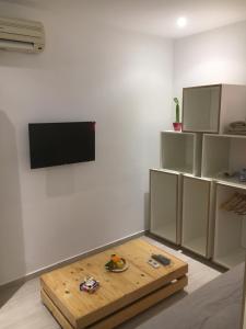 - un salon avec une table et une télévision murale dans l'établissement Le cocon de Sfax, à Sfax