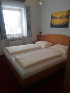 2 Einzelbetten in einem Schlafzimmer mit Fenster in der Unterkunft Ferienwohnung 2 Haus Dörfler in Abtenau